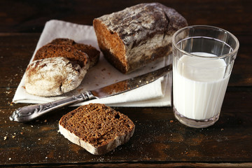 Sliced rye bread, glass of fresh milk and knife