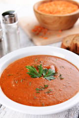Delicious lentil cream-soup on table close-up