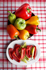 Pepper on oval and round plate on fabric background