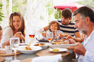 Obraz na płótnie Canvas Multi Generation Family Enjoying Meal In Restaurant