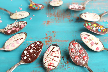 Spoons with tasty chocolate for party on old blue wooden table