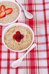 Tasty oatmeal with berries on napkin close-up