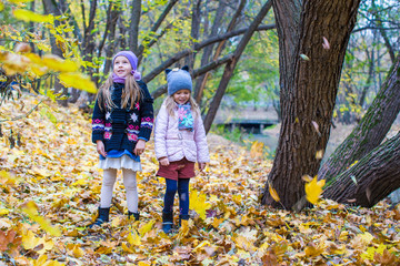 Two adorable girls outdoors in autumn forest