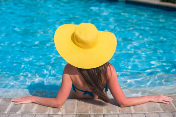 Fototapeta na wymiar Young beautiful woman enjoying vacation in the pool