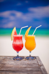 Two cocktails fresh watermelon and mango on background of