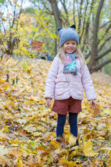 Adorable little girl at beautiful autumn day outdoors