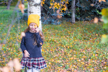 Little girl in autumn park outdoors
