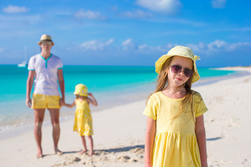 Adorable little girls and happy father on tropical white beach