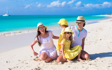 Young family of four with two kids at tropical white beach