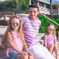 Family of three sitting on beach enjoying ocean view