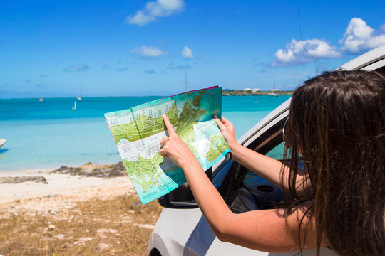 Young attractive woman with great map of island in the car