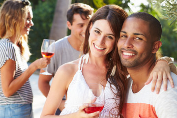 Couple With Friends Drinking Wine And Relaxing Outdoors
