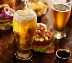 bier wordt in glas gegoten met gastronomische hamburgers