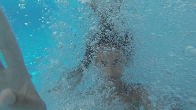 Girls jumping and  diving under water in the pool