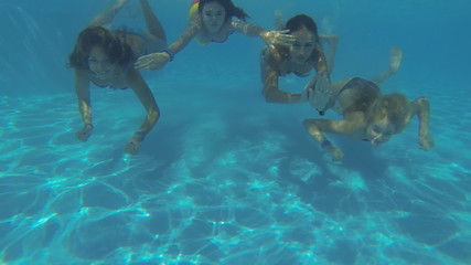 Beautiful girls in bikini swimming underwater