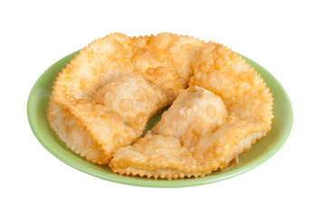 cheburek stuffed on a green plate isolated on white background
