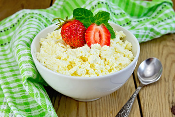 Curd with strawberries in bowl on board