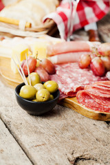 Charcuterie assortment and olives on wooden background