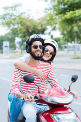Cheerful couple on scooter © DragonImages