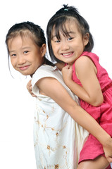 Asian little girl carries her sister on her back