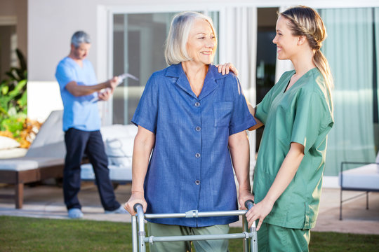 Smiling Disabled Woman And Nurse Looking At Each Other
