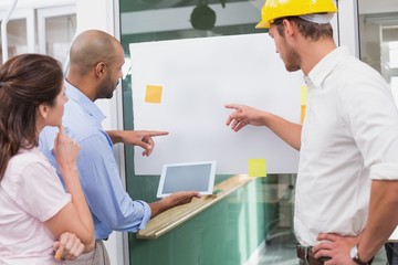 Obraz premium Architect team brainstorming together using digital tablet