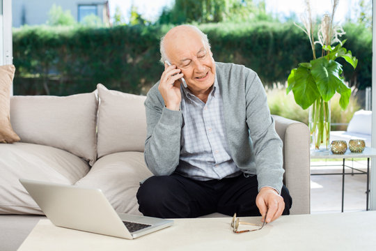Senior Man Answering Smartphone At Nursing Home Porch