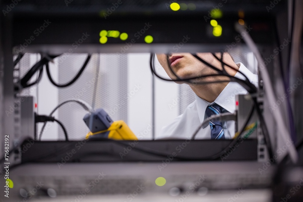Aufkleber technician using digital cable analyzer on server