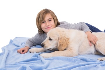 Child rubbing his dog lying on a blanket