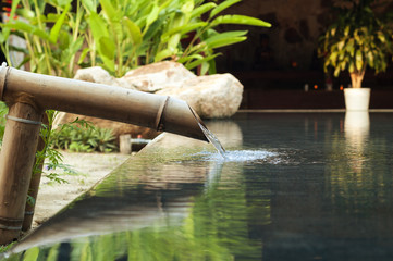 water falling down from bamboo pipe - obrazy, fototapety, plakaty