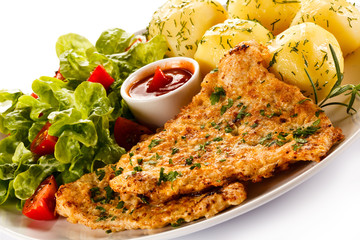 Fried pork chop, boiled potatoes and vegetable salad