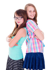 Portrait of two teen girls standing back-to-back