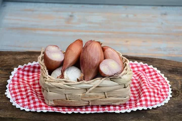 Foto auf Leinwand sjalotjes,knoflook en uien in een mandje met kleedje © trinetuzun