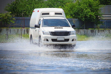Obraz na płótnie Canvas Splash by a car as it goes through flood water