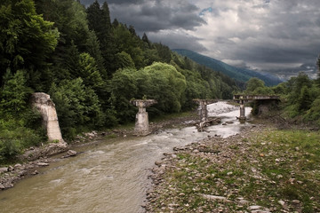 The destroyed bridge through the river Pruth in the Carpathians,