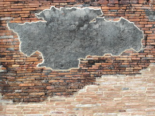 Patch of blank grey concrete on an old brick wall creates a background with copyspace.