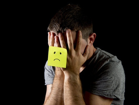 young man suffering depression and stress alone with sad post it