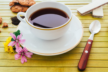 Cup of english tea with assorted chocolate cookies