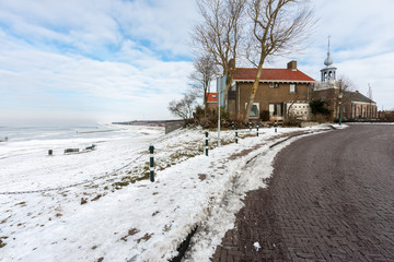 Coast of Dutch village Urk in wintertime with church and houses