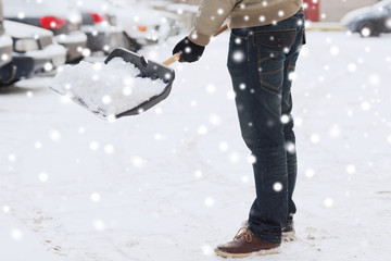 closeup of man digging snow with shovel near car