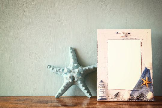 vintage nautical frame with starfish on wooden table. retro filt