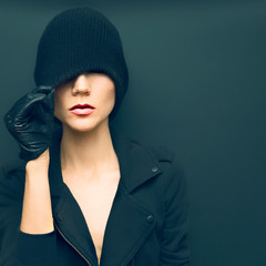 glamorous lady on black background in trendy gloves and hat autu