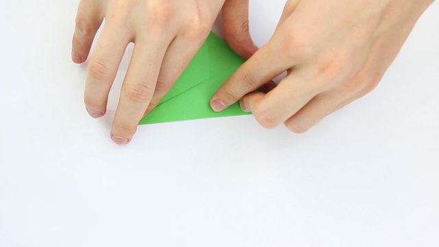 hands of guy make origami crane on white background, time lapse