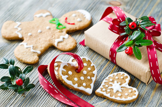 Christmas gift box and gingerbread cookies on wooden background