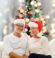 happy senior couple in santa helper hats