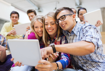 group of smiling students with tablet pc