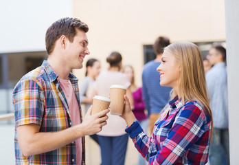 group of smiling students with paper coffee cups