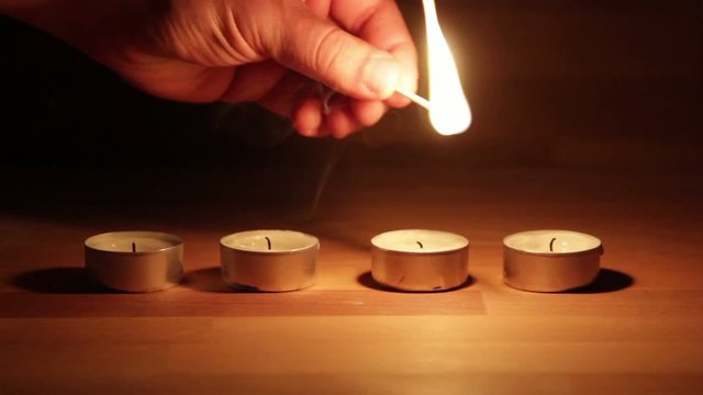 Lighting a line of Tea Candles