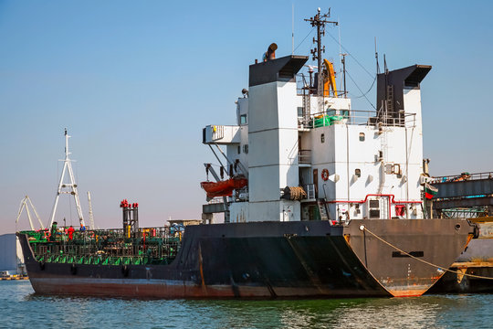Black tanker loading. Industrial cargo ship moored in Burgas