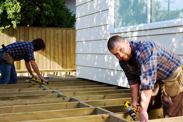 Two carpenters building a deck